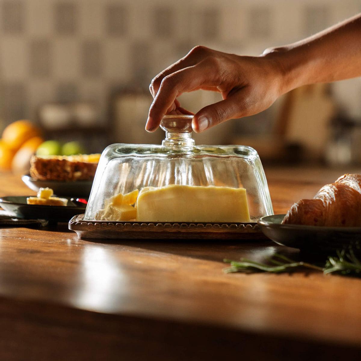 clear glass butter dish with wooden base