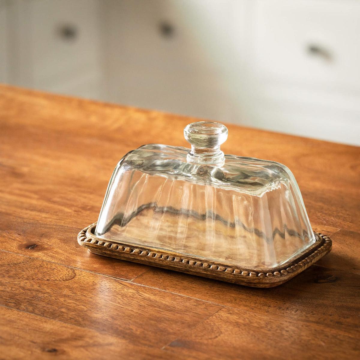 clear glass butter dish with wooden base