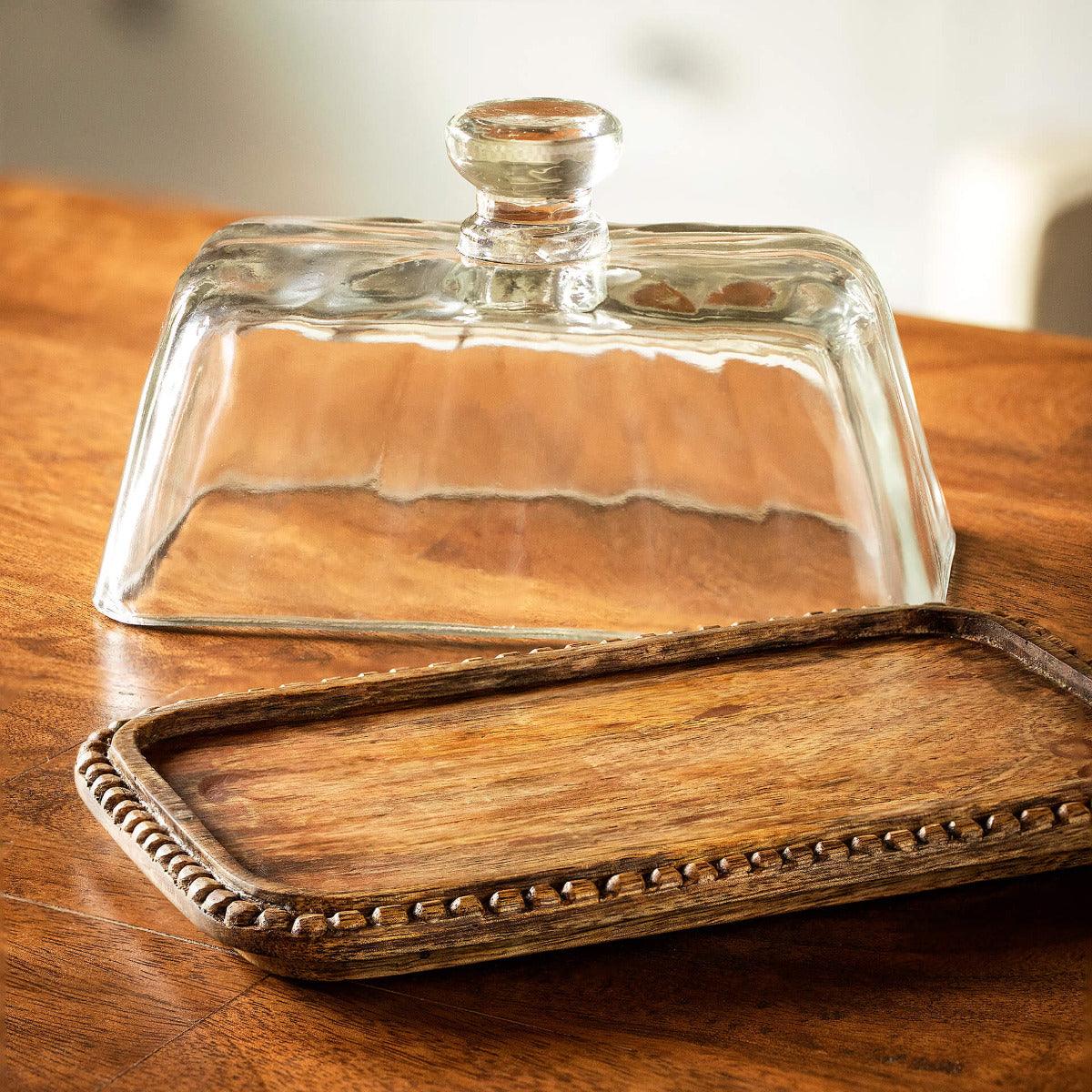 clear glass butter dish with wooden base